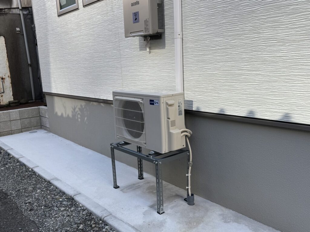 エアコン室外機の浸水対策として設置された高置台(架台)。かさ上げにより冠水時の故障リスクを軽減する、点検時に追加された二次防水対策。