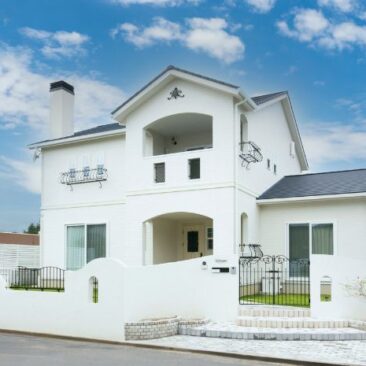 アーチと曲線が印象的な、白を基調としたフレンチモダンの二階建て住宅の外観