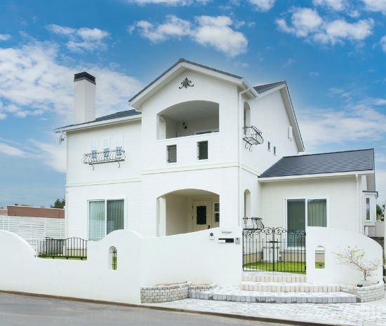 アーチと曲線が印象的な、白を基調としたフレンチモダンの二階建て住宅の外観