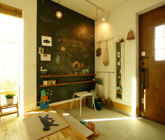 黒板塗料の壁にメッセージやイラストを描ける、明るく開放的な土間玄関