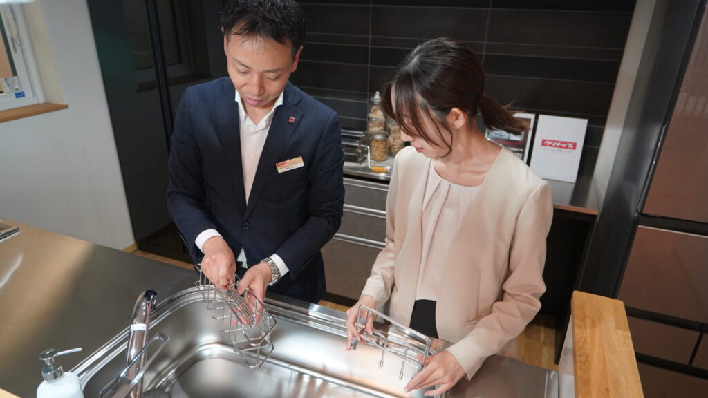 クリナップのステンレスシンクで製品パーツを確認する藤田所長と大塚さん。使いやすさと衛生性に配慮した機能美を体感