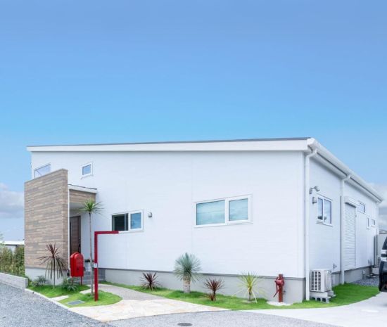 白を基調としたシンプルな外観と広い庭が印象的な、家族がつながる平屋風の住まい