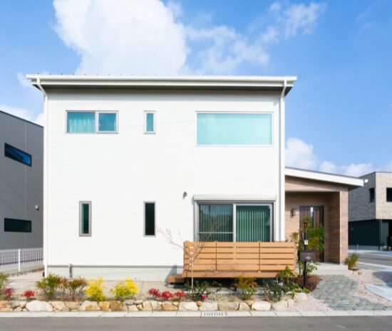 白い外壁が印象的な、シンプルで都会的な二階建て住宅の外観