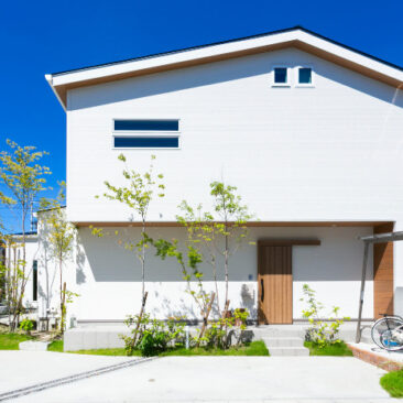 植栽と木の軒天が調和する、離れとロフトを備え将来を見据えたナチュラルな二階建て住宅の外観