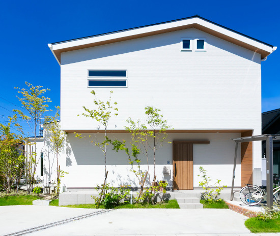 植栽と木の軒天が調和する、離れとロフトを備え将来を見据えたナチュラルな二階建て住宅の外観