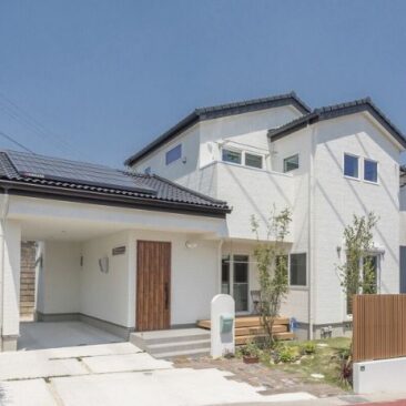 屋久島の杉と白い外壁が調和した、シンプルモダンな二階建て住宅の外観