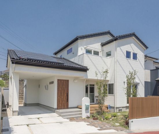 屋久島の杉と白い外壁が調和した、シンプルモダンな二階建て住宅の外観