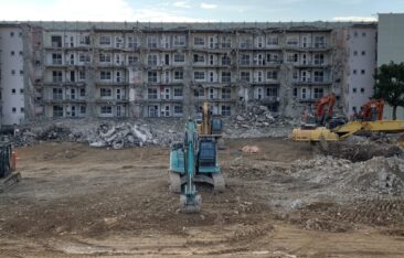 解体工事が進む大規模な団地の風景。複数のショベルカーが稼働し、コンクリートの建物が取り壊されるスクラップアンドビルドの様子。