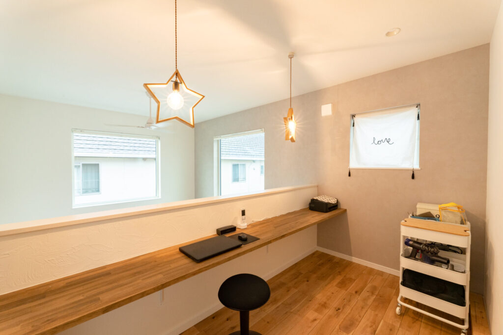 吹き抜けに面した2階ホールのファミリーワークスペース。星型のペンダントライトがおしゃれな、家族の気配を感じながら作業ができるオープンな間取り。
