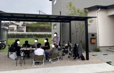 オーナー様邸のカーポート下で開催された1周年記念BBQパーティー。ご家族やご友人が集まり、お庭で楽しく食事を囲む様子。