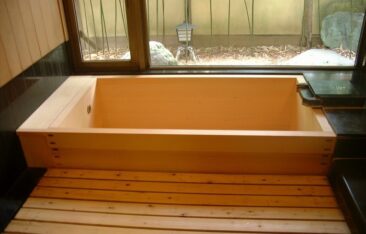 坪庭を望む高級感あふれる檜風呂(ひのきぶろ)。御影石の洗い場と天然木の浴槽が調和した、和モダンな浴室デザイン。